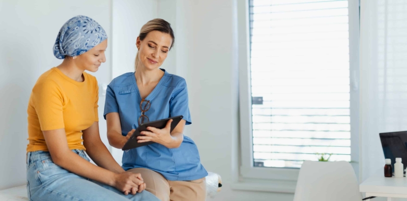 Teenage oncology patient talking with doctor